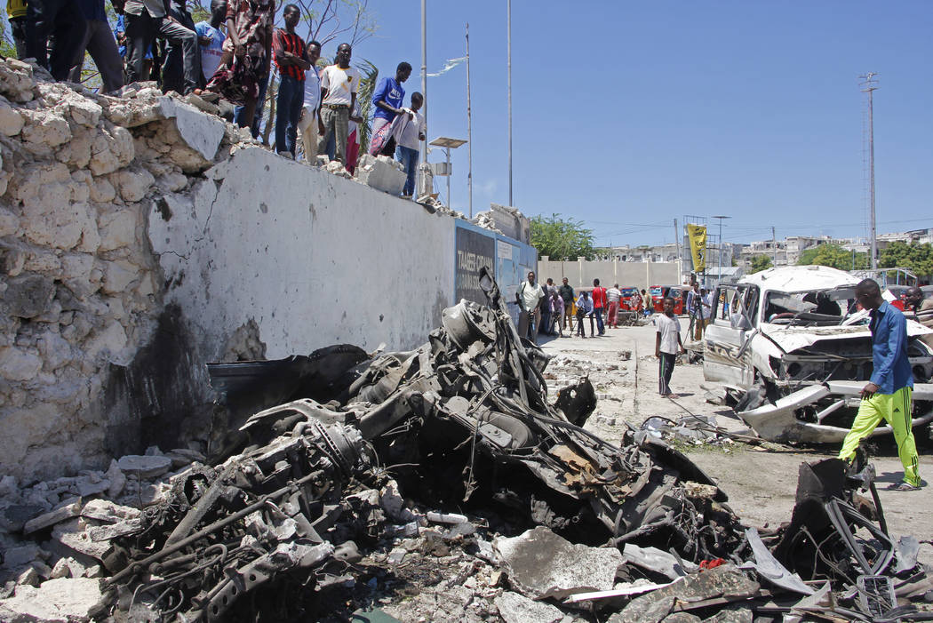 Somalis look at the wreckage after a suicide car bomb attack in the capital Mogadishu, Somalia ...