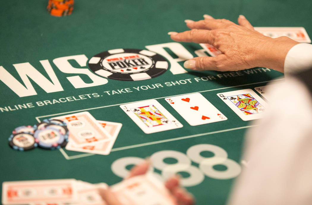 A dealer plays a hand on day one of the main event during the World Series of Poker tournament ...