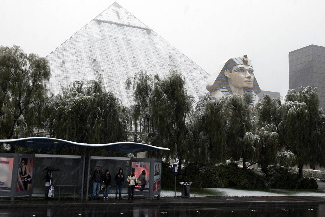 JOHN GURZINSKI/LAS VEGAS REVIEW JOURNAL NEWS----People wait for a bus as falling snow covers t ...