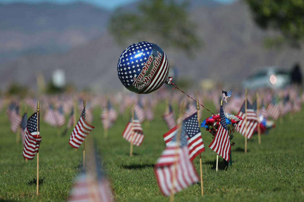 Flags fly above grave sites during the annual “Flag-In” event at the Southern Nev ...