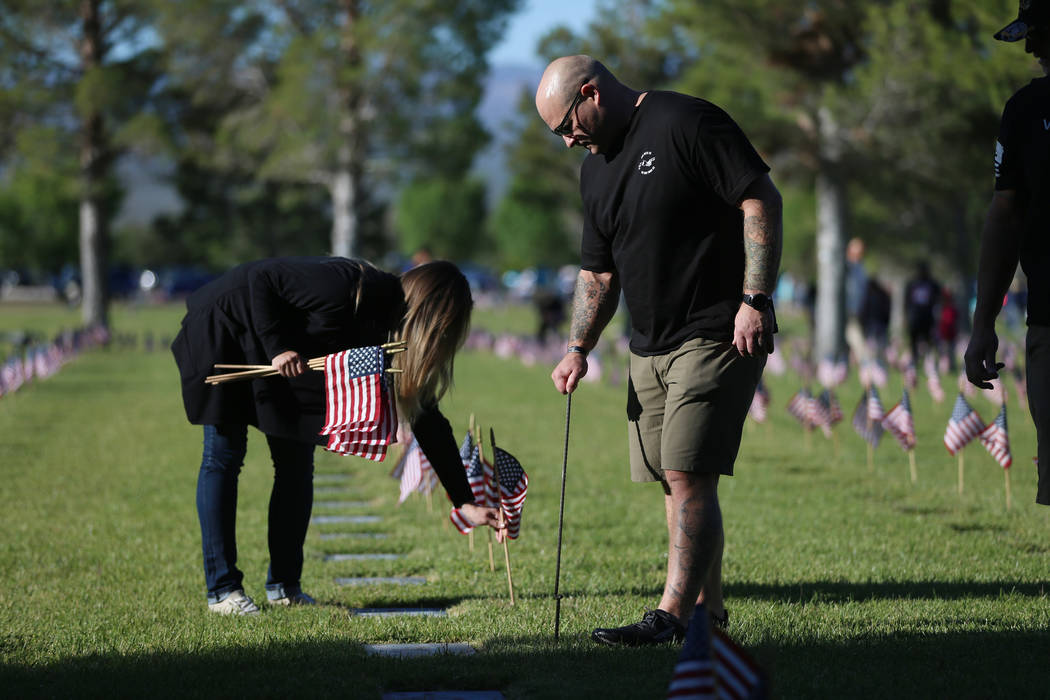 Volunteers Wendy Hackman, left, and her husband Monte, U.S. Army veteran, assist with placing A ...