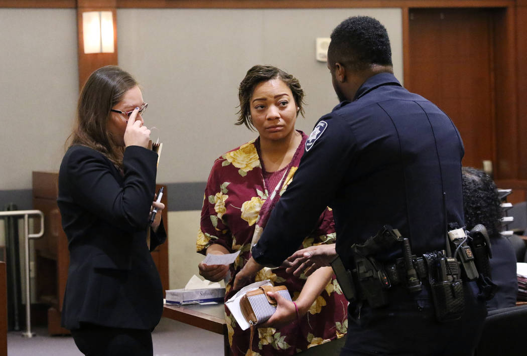 Cadesha Bishop, 25, center, accused of shoving a 74-year-old man off a bus, listens to a court ...