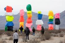 Tourists bundled up against the cold weather explore the area at Seven Magic Mountain near Jean ...