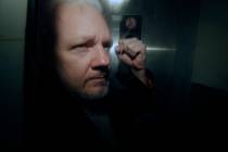 FILE - In this May 1, 2019, file photo, WikiLeaks founder Julian Assange puts his fist up as he ...