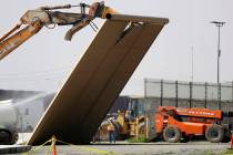 A border wall prototype falls during demolition at the border between Tijuana, Mexico, and San ...