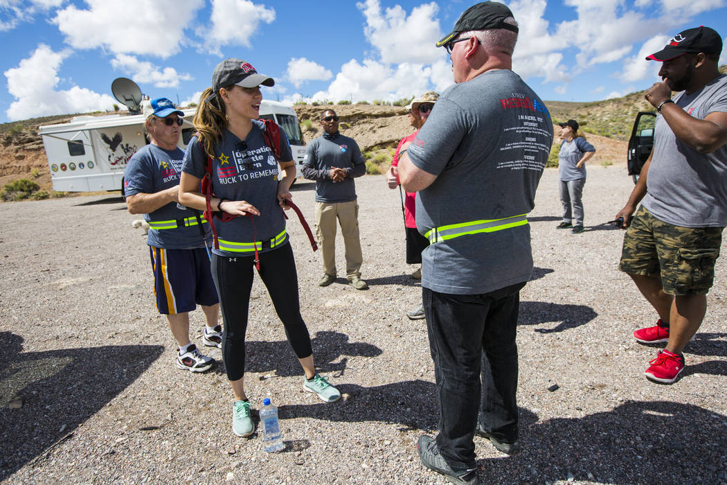 Volunteer Kaci Schroeder, left, of Las Vegas, straps on a rucksack containing dog tags after a ...