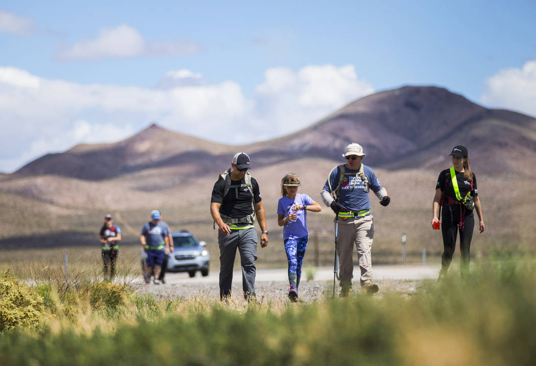 Navy veteran Jelani Hale, of Las Vegas, from left, walks with daughter Jet, 9, retired civilian ...