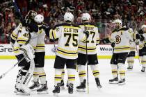 Boston Bruins goalie Tuukka Rask, left, of Finland, is congratulated by teammates following Gam ...