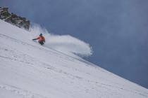 A snowboarder makes his way downhill in fresh snow at Mammoth Mountain ski area on May 17, 2019 ...