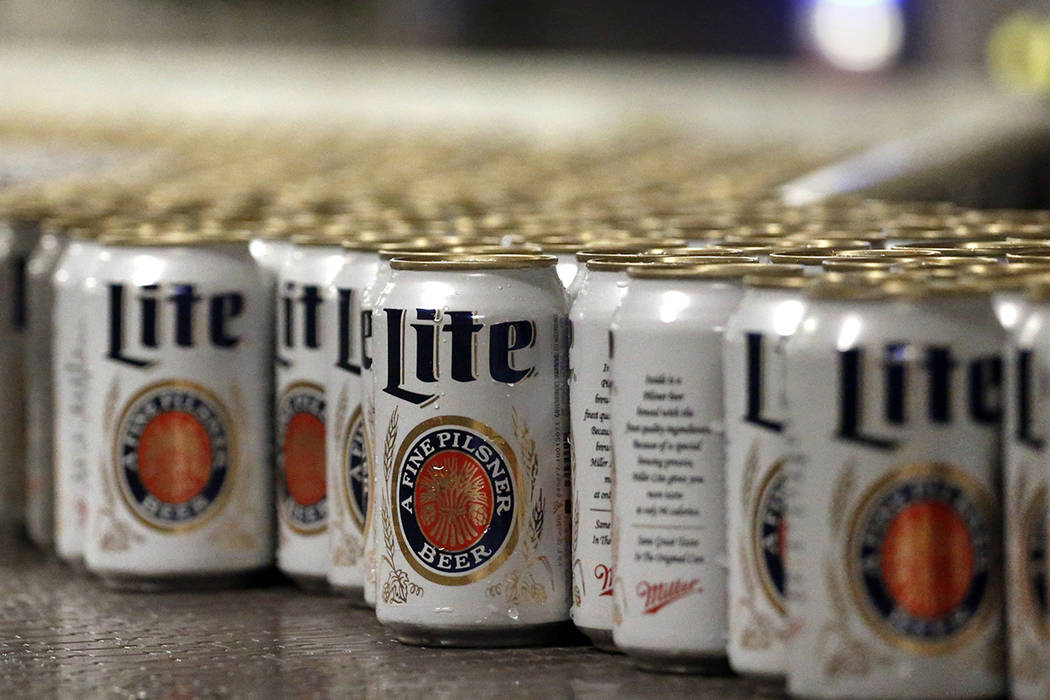 In this March 11, 2015 file photo, newly-filled and sealed cans of Miller Lite beer move along ...