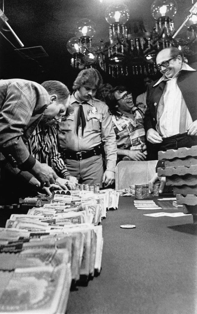 "Dolly" Doyle Brunson, right, of Fort Worth, Texas, looks at a trail of $100 bills he just won ...