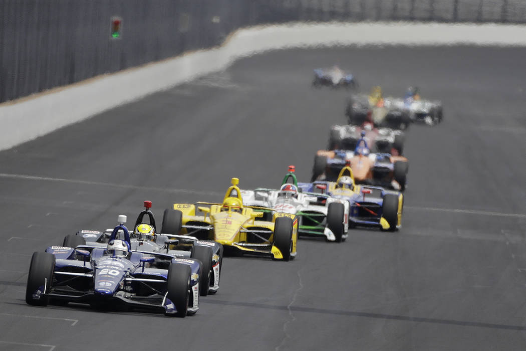 Ed Carpenter leads a group of cars into turn one during the final practice session for the Indi ...