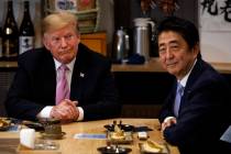 President Donald Trump sits at dinner with Japanese Prime Minister Shinzo Abe, Sunday, May 26, ...