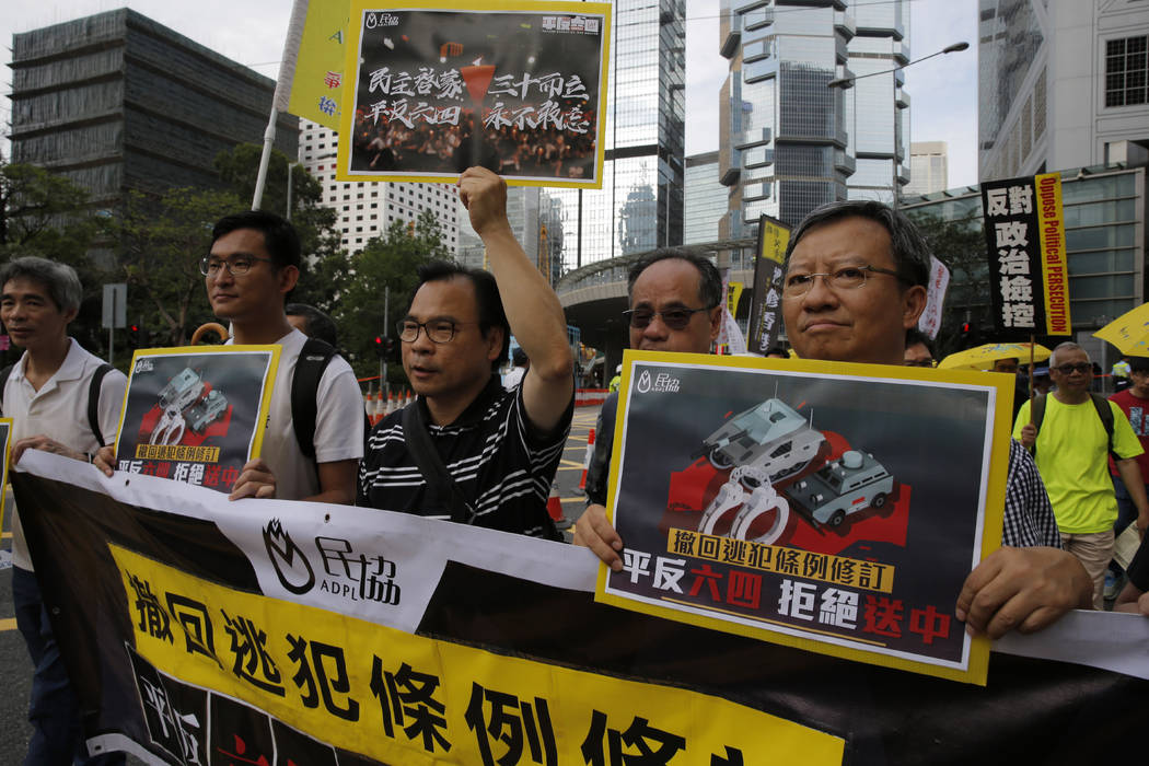 Pro-democracy demonstrators carry placards with Chinese reads "Withdraw extradition law, V ...