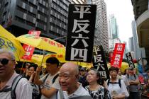 Pro-democracy protesters carry placards with Chinese reads "Vindicate June 4th" and & ...