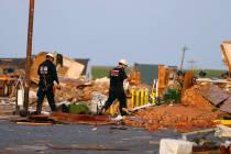 Workers look through tornado damage at the American Budget Value Inn in El Reno, Okla., Sunday, ...