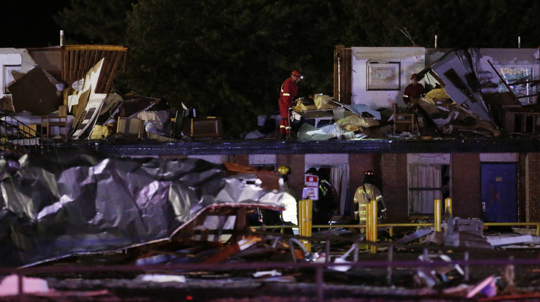 Emergency workers check what is left of the second floor of a hotel, Sunday, May 26, 2019, in E ...