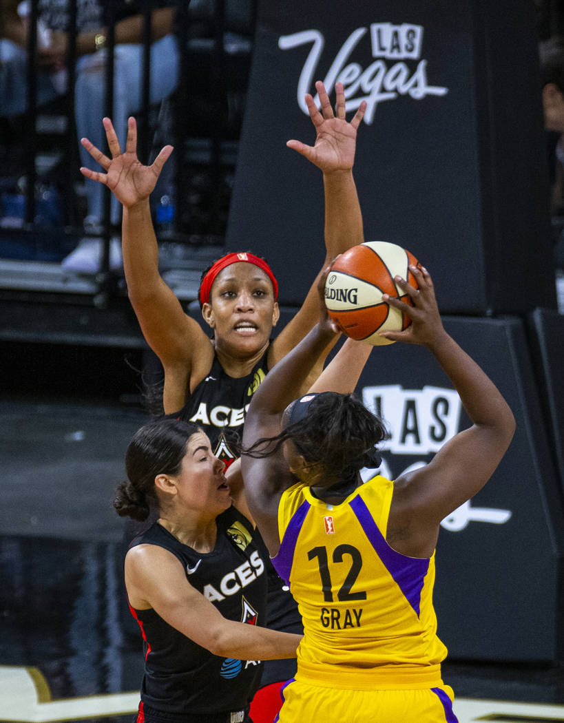 Las Vegas Aces center A'ja Wilson (22), center, and guard Kelsey Plum, left, defend the basket ...