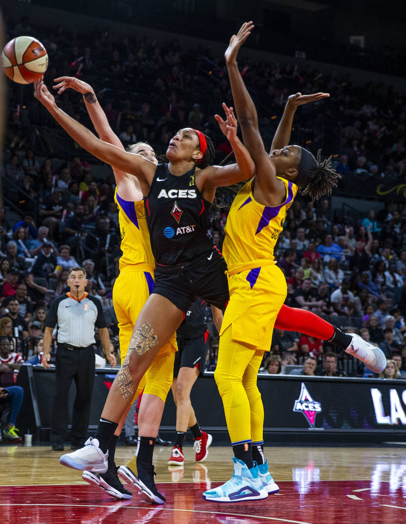 Las Vegas Aces center A'ja Wilson (22) splits the defense of Los Angeles Sparks forward/center ...