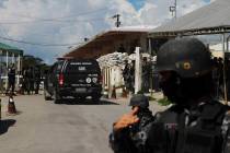 Police guard the entrance to the Anisio Jobim Prison Complex after a deadly riot erupted among ...