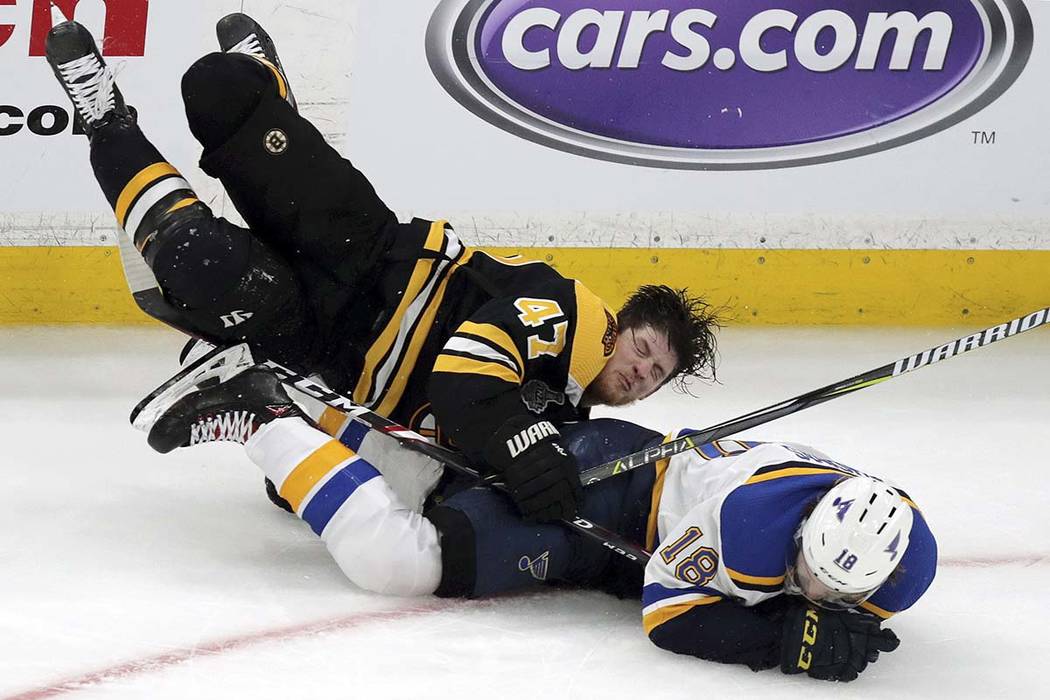 Boston Bruins' Torey Krug (47) and St. Louis Blues' Robert Thomas (18) crash to the ice during ...