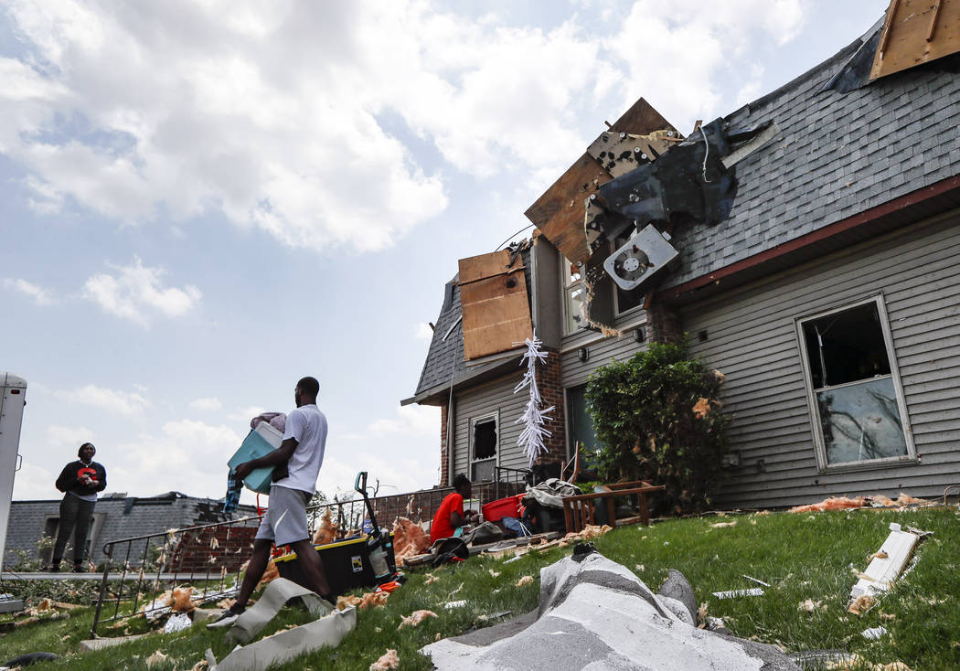 Residents remove belongings from their damaged homes at the River's Edge apartment complex, Tue ...