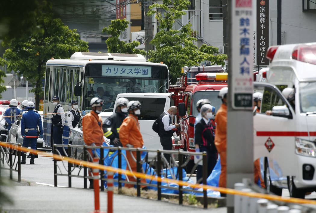 A school bus, center, is parked at the scene of an attack in Kawasaki, near Tokyo Tuesday, May ...
