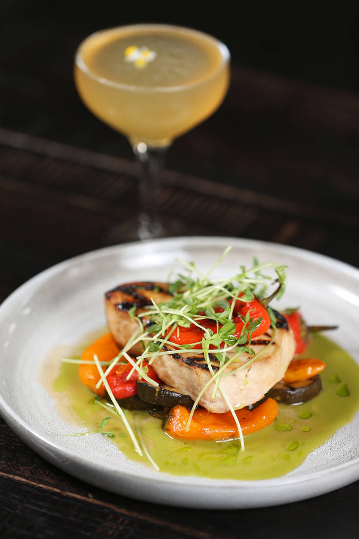 The swordfish is served with hot and sweet marinated peppers, grilled zucchini and sorrel, at t ...