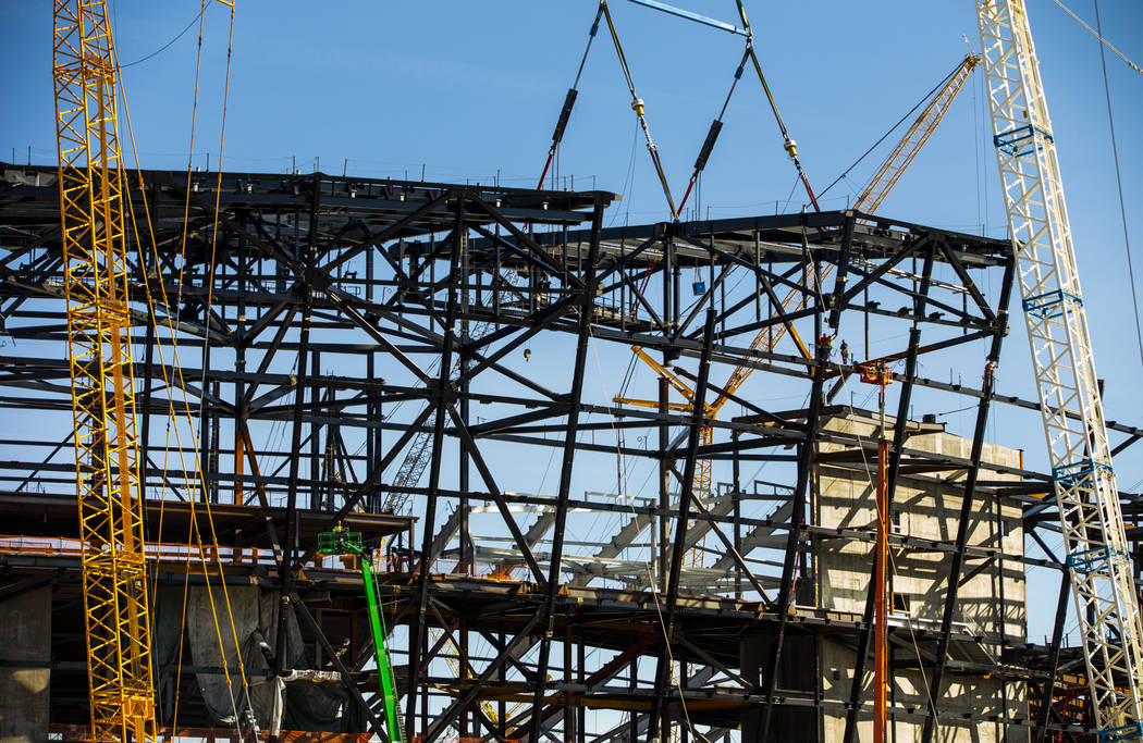 The newest truss is lowered into place and attached by awaiting steelworkers at the top of Raid ...