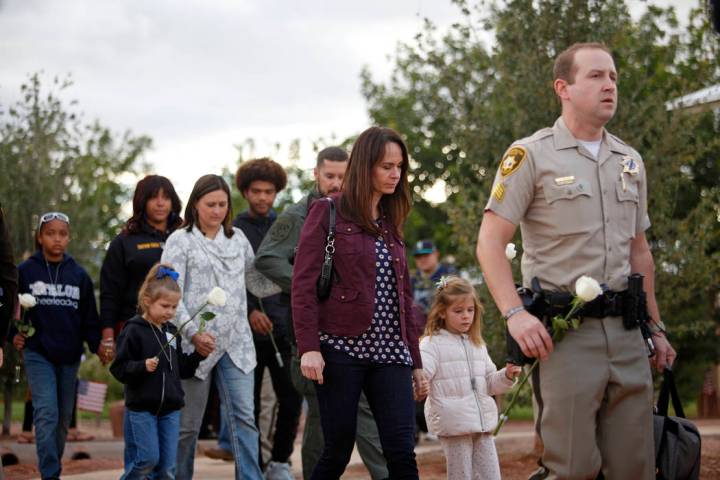 Nicole Beck, the widow of Las Vegas police officer Alyn Beck, walks with her daughter Katriann, ...