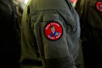 A service member wears a patch that says "Make Aircrew Great Again" as they listen to ...
