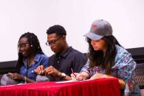 Savannah Mantanona, of Basic High School, right, signs paperwork during a ceremony for high sch ...