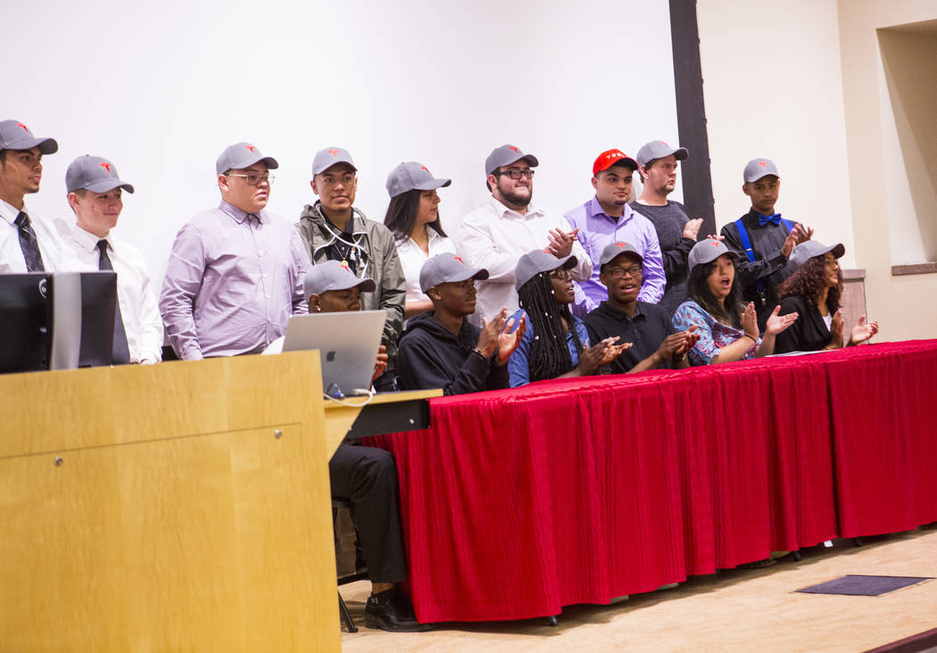 New Tesla hires, who recently graduated high school, pose for a photo after a signing ceremony ...