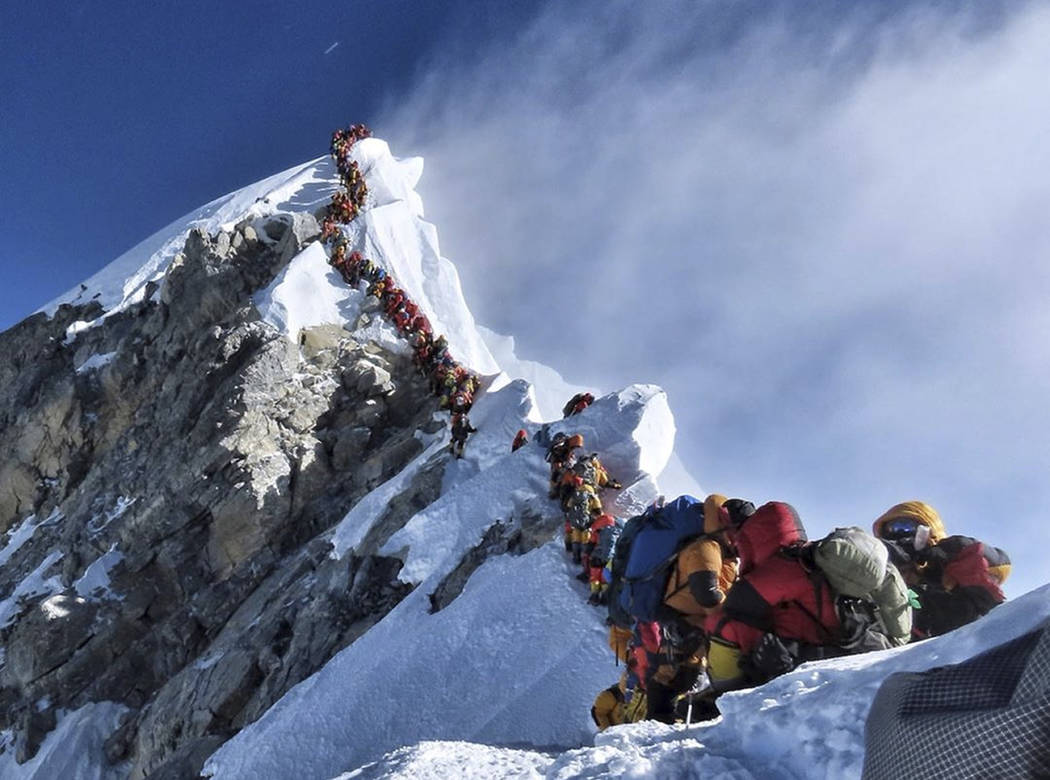 In a May 22, 2019 photo, a long queue of mountain climbers line a path on Mount Everest. About ...