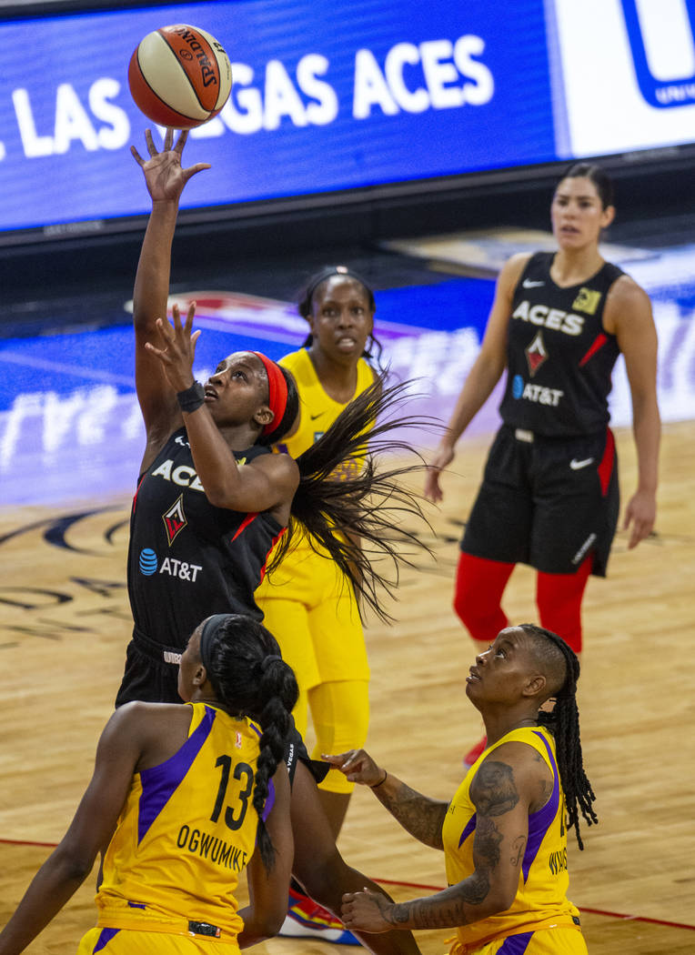 Las Vegas Aces guard Jackie Young (0) lays up the ball past Los Angeles Sparks forward/center C ...