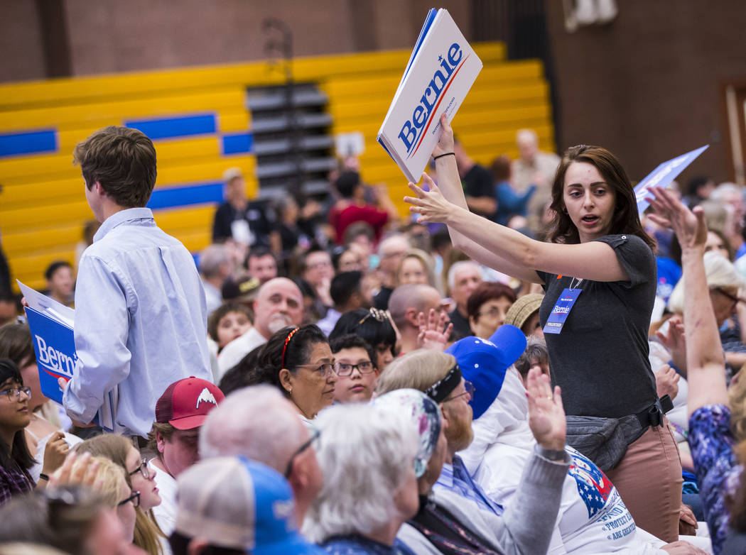 A volunteer hands out signs in support of Democratic presidential candidate Sen. Bernie Sanders ...