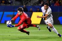 Portland Timbers goalkeeper Jake Gleeson, left, stops a shot as LA Galaxy forward Jose Villarre ...