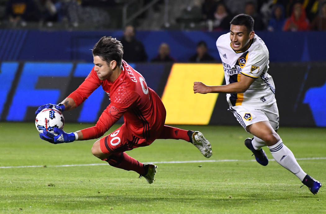Portland Timbers goalkeeper Jake Gleeson, left, stops a shot as LA Galaxy forward Jose Villarre ...