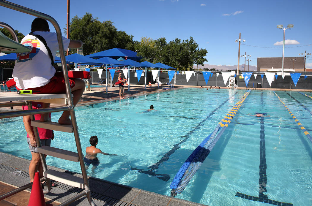 Pool lifeguards, including Sophia Morris, far right, watch as children swim at Boulder City poo ...