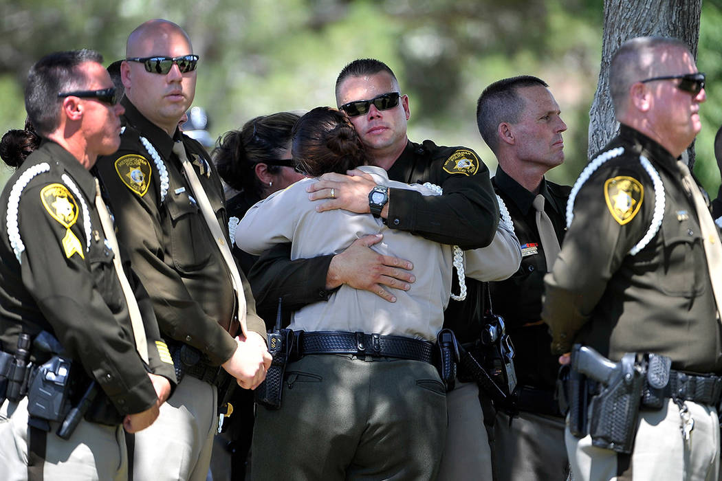 Las Vegas police officers console each during a service for officer Igor Soldo at Palm Northwes ...