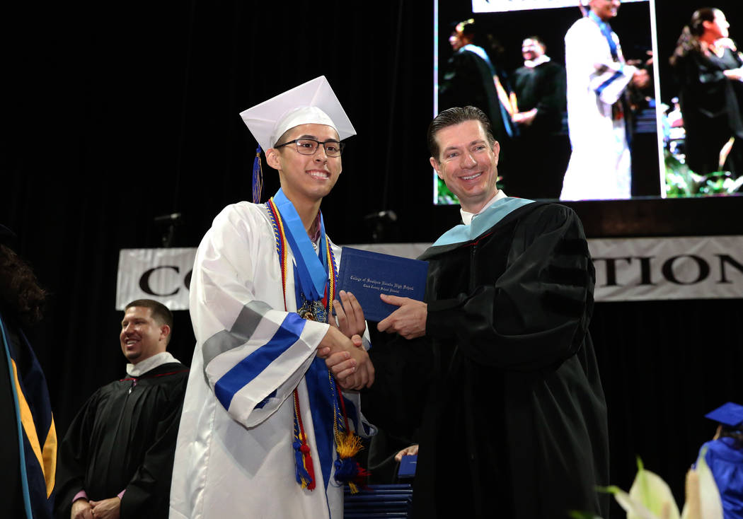 College of Southern Nevada High School student Dominic Calicdan, left, receives his diploma fro ...