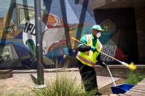 A cleaning crew sweeps up in front of LAPD Central Community Police Station in downtown Los Ang ...
