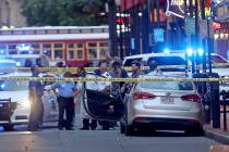 Investigators look at a Kia Forte with a shattered driver's window after a Louisiana state troo ...