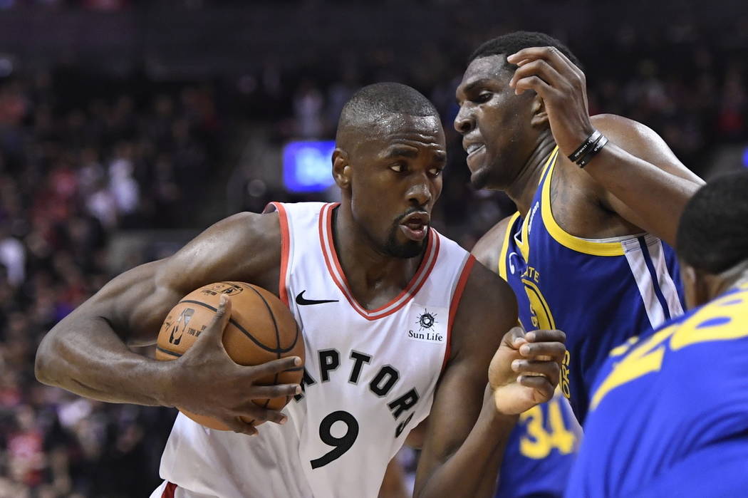 Toronto Raptors center Serge Ibaka (9) holds the ball as Golden State Warriors centre Kevon Loo ...