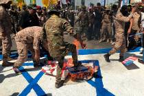 Iraqi Popular Mobilization Forces burn representations of U.S. and Israeli flags during "a ...