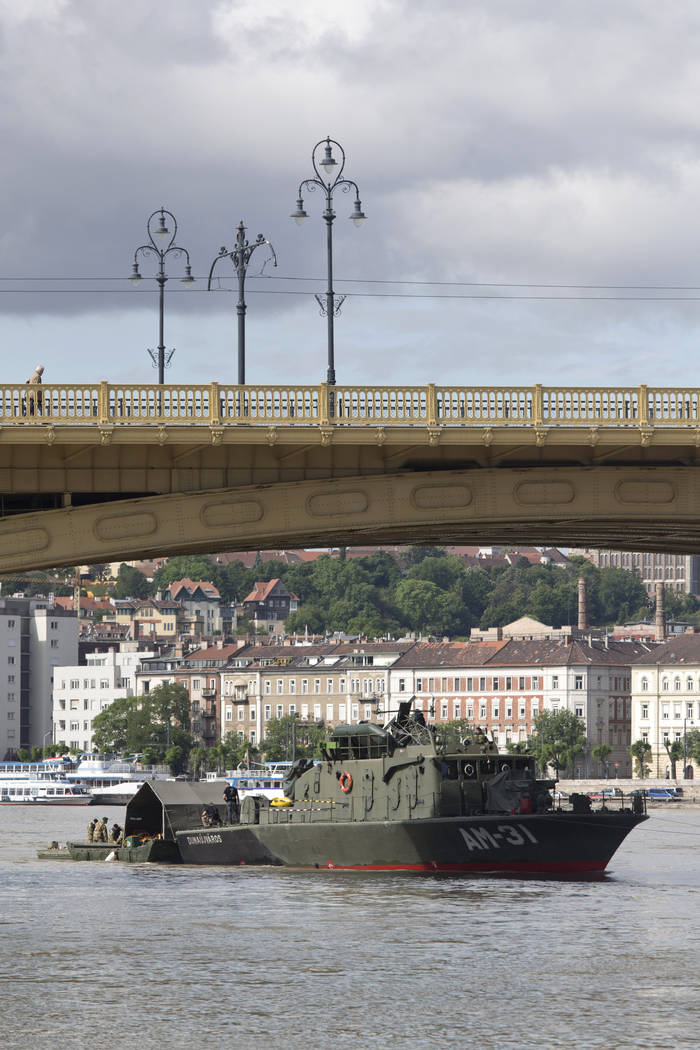 Rescue crew members are seen at work on the Danube River underneath the Margit Bridge where a s ...
