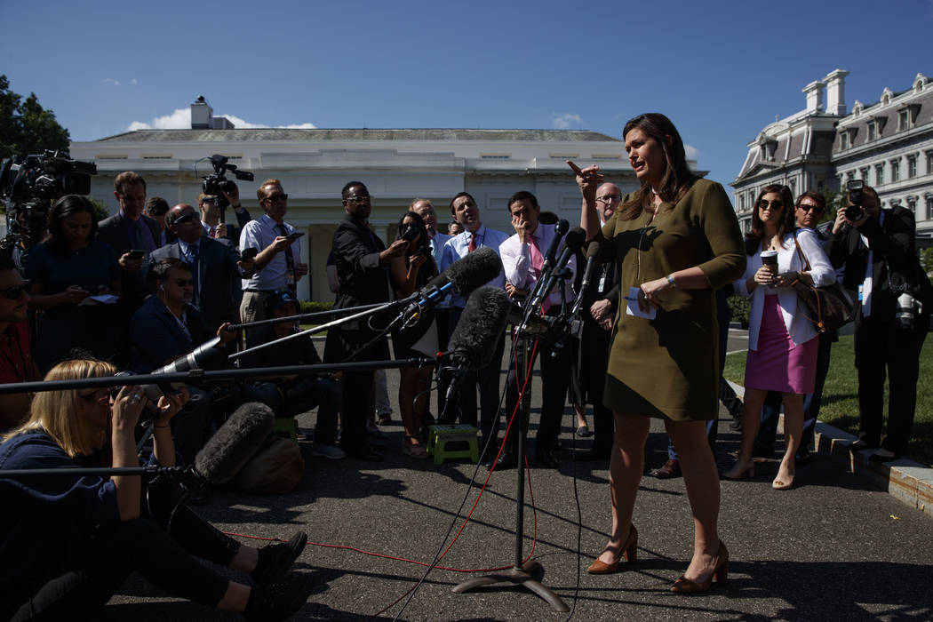 White House press secretary Sarah Sanders talks to reporters outside the White House, Friday, M ...