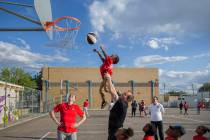 UNLV head basketball coach T.J. Otzelberger, middle, gives a boost to Ryan Fraley, 4, during a ...