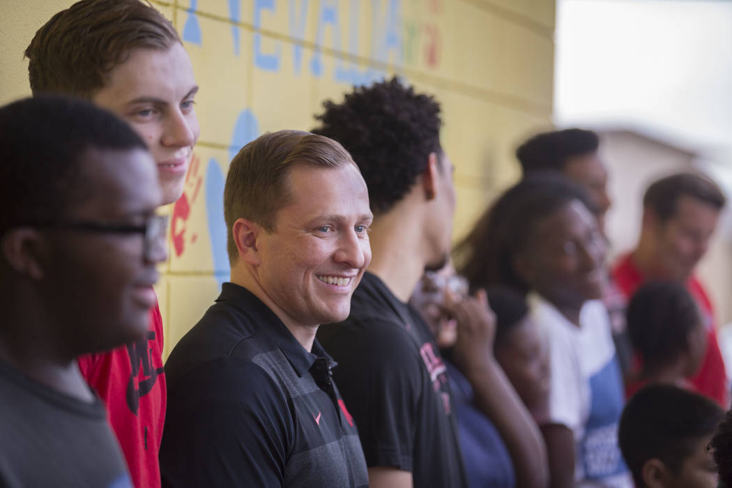 UNLV head basketball coach T.J. Otzelberger, third from left, jokes around with kids during a y ...