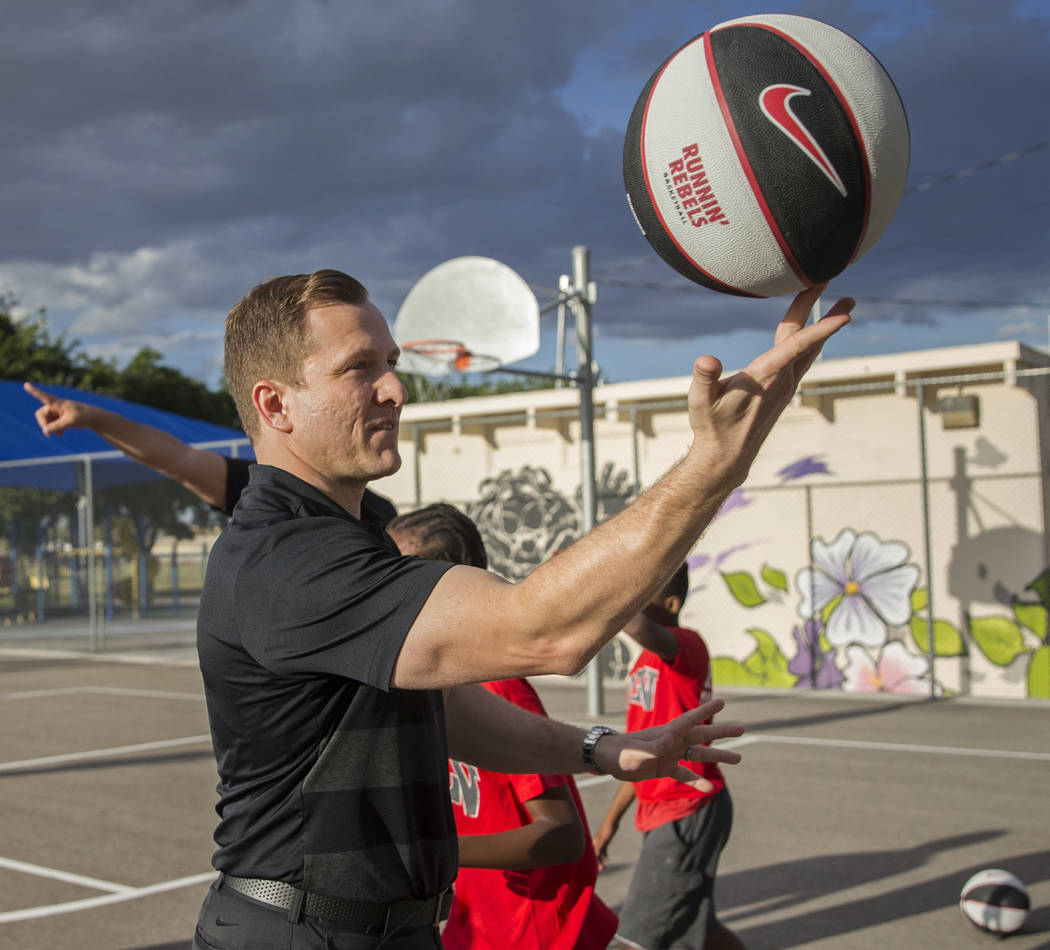 UNLV head basketball coach T.J. Otzelberger spins a basketball on his finger during a youth cli ...